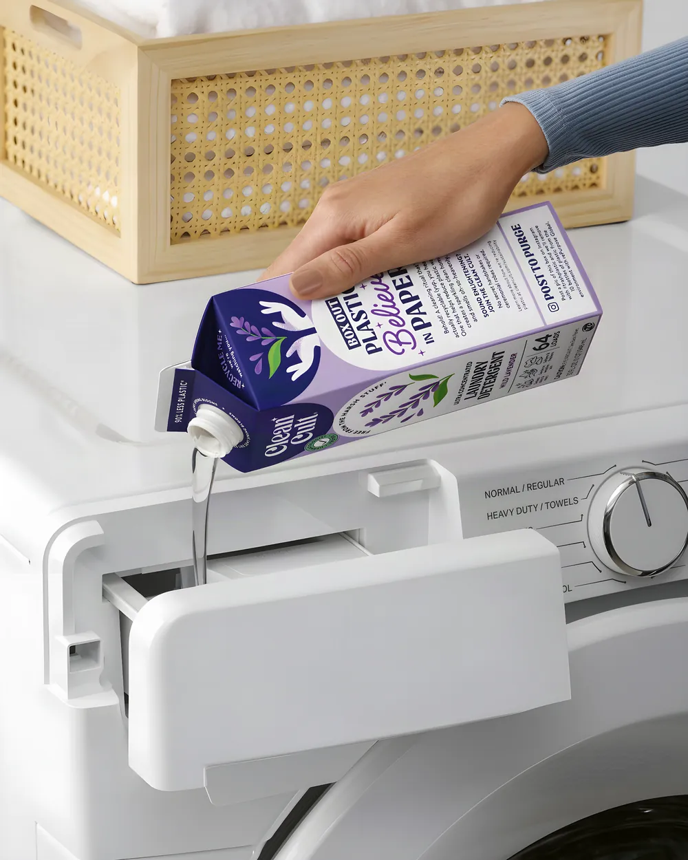 Pouring Wild Lavender detergent into a washer's dispenser drawer