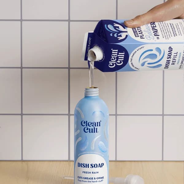 Pouring Fresh Rain dish soap from a refill carton into an aluminum bottle