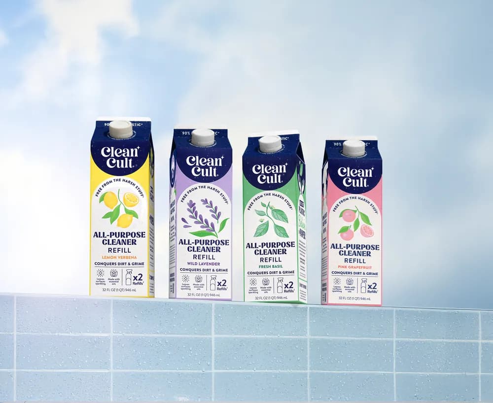 Four all-purpose cleaner refill cartons on a tiled ledge against a blue sky