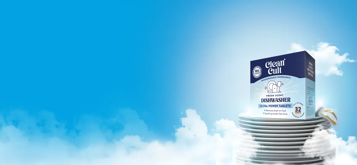 A box of dishwasher tablets on a stack of white plates in the clouds